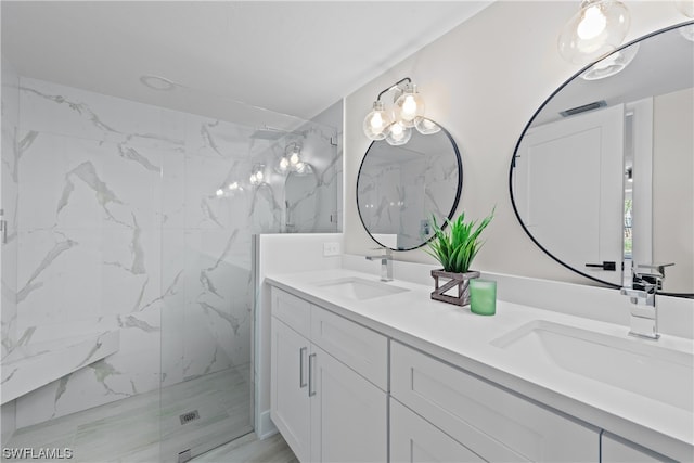 bathroom with dual vanity and an enclosed shower