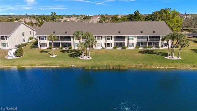 rear view of property featuring a balcony, a lawn, and a water view