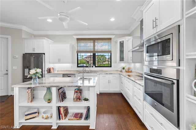 kitchen featuring white cabinets, light stone countertops, stainless steel appliances, and a center island with sink