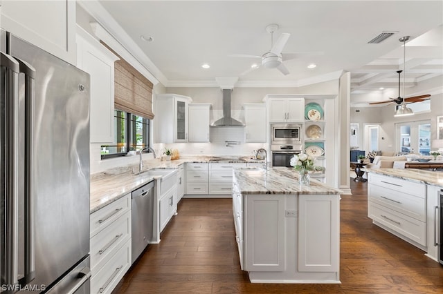 kitchen featuring a kitchen island, sink, appliances with stainless steel finishes, white cabinets, and wall chimney exhaust hood