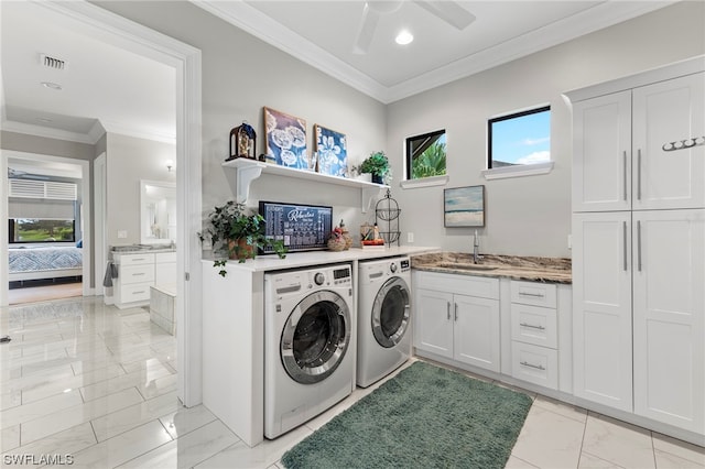 clothes washing area with washer and dryer, cabinets, sink, ornamental molding, and ceiling fan