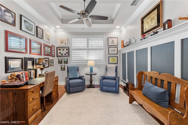 sitting room with ceiling fan, crown molding, and a tray ceiling