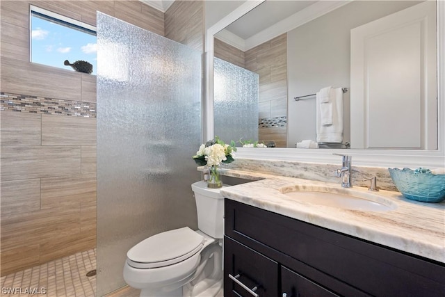 bathroom featuring toilet, vanity, and a tile shower