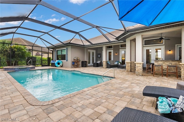 view of swimming pool featuring glass enclosure, an in ground hot tub, exterior bar, a patio, and ceiling fan