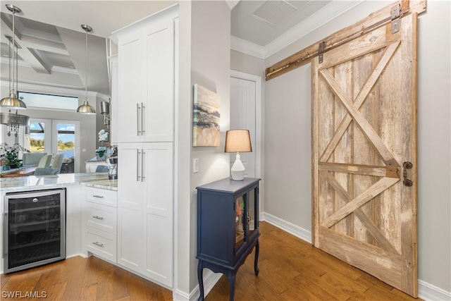 bar with white cabinets, beverage cooler, beamed ceiling, a barn door, and coffered ceiling