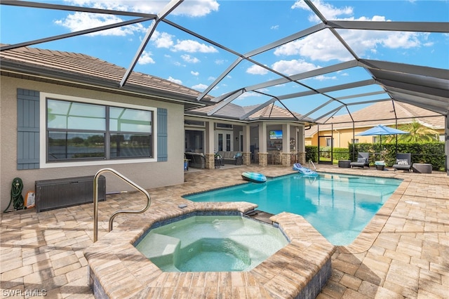 view of pool with an in ground hot tub, glass enclosure, and a patio