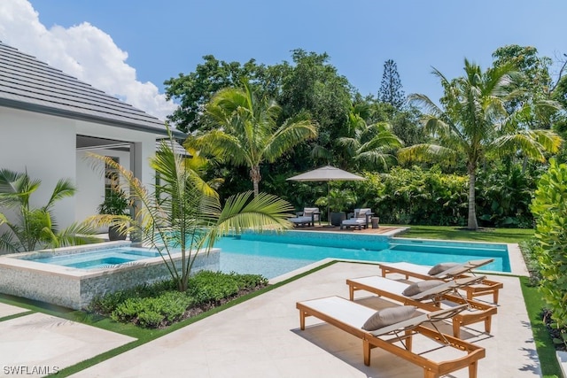 view of pool with a patio area and an in ground hot tub