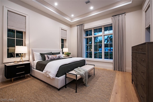 bedroom featuring a raised ceiling and hardwood / wood-style floors