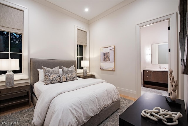 bedroom with ensuite bath, hardwood / wood-style floors, and crown molding