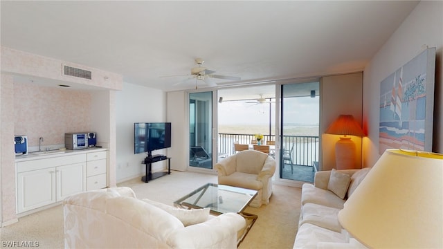 4753 Estero Blvd Unit 1005, Fort Myers Beach, FL 33931 - living room with light colored carpet, ceiling fan, and a wall of windows