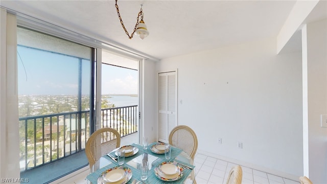 4753 Estero Blvd Unit 1005, Fort Myers Beach, FL 33931 - dining room featuring a water view, tile patterned floors, a wall of windows, and baseboards