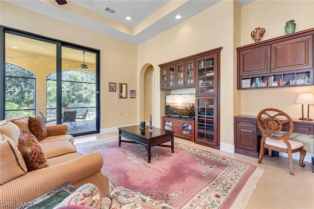 living area with light tile patterned floors, visible vents, baseboards, recessed lighting, and arched walkways