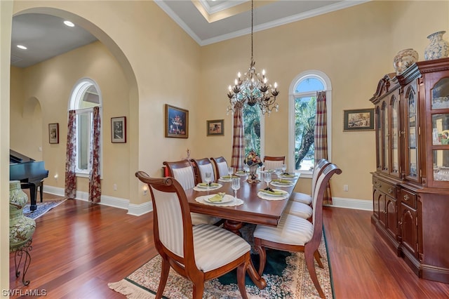 dining area featuring dark hardwood / wood-style floors, ornamental molding, and a notable chandelier