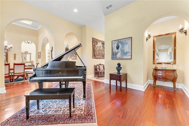 misc room featuring a chandelier, crown molding, and wood-type flooring