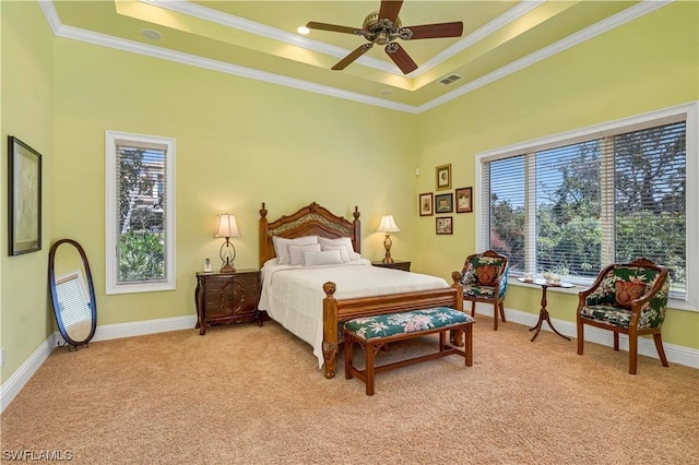 carpeted bedroom featuring ceiling fan, crown molding, and a tray ceiling