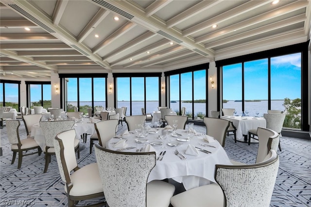 dining area featuring a water view, light colored carpet, beamed ceiling, and coffered ceiling