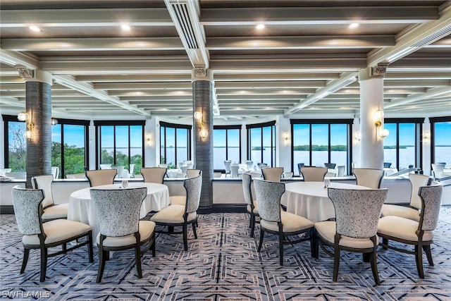 dining area with a water view, beam ceiling, and carpet