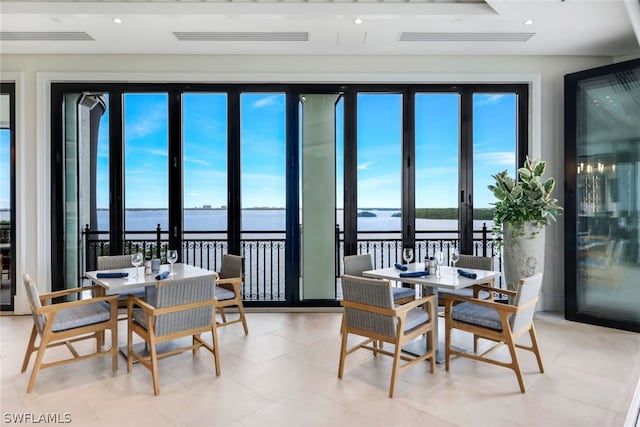 dining space featuring a water view, french doors, and a wealth of natural light