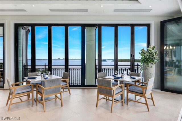 dining room with recessed lighting, visible vents, and a water view