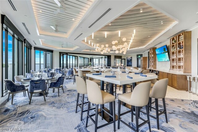 dining room featuring a tray ceiling and ceiling fan with notable chandelier