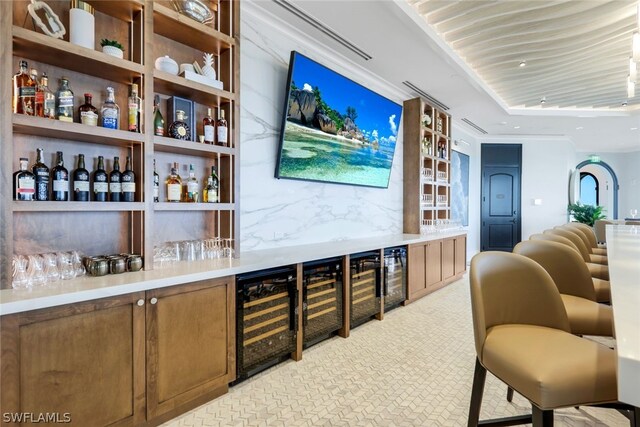 bar featuring beverage cooler, decorative backsplash, recessed lighting, and a dry bar