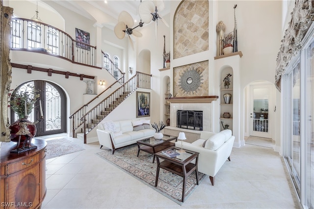 living room featuring light tile floors, a notable chandelier, french doors, and a towering ceiling