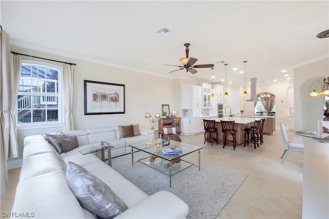 living room featuring light tile floors, crown molding, and ceiling fan with notable chandelier