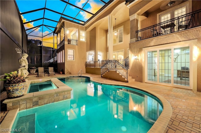 view of pool with an in ground hot tub, a patio, and a lanai