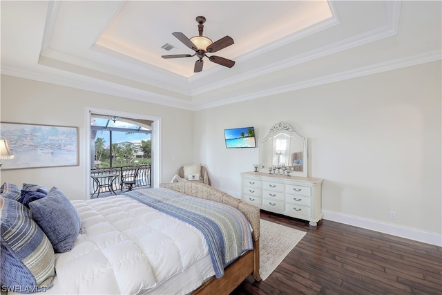 bedroom with ceiling fan, ornamental molding, a tray ceiling, access to outside, and dark hardwood / wood-style flooring