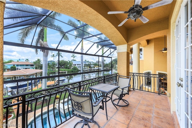 balcony featuring ceiling fan and a water view