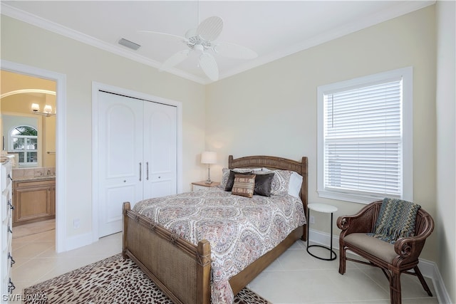 tiled bedroom featuring ceiling fan with notable chandelier, sink, ornamental molding, ensuite bathroom, and a closet