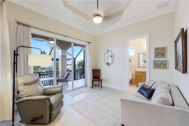 living room with light tile flooring, a raised ceiling, ornamental molding, and ceiling fan