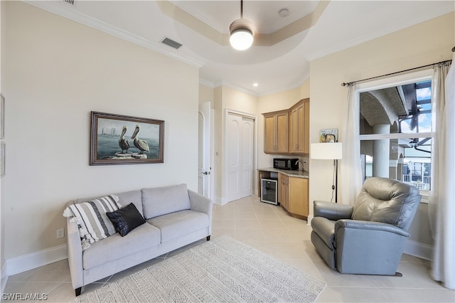 tiled living room featuring wine cooler, crown molding, a tray ceiling, and ceiling fan