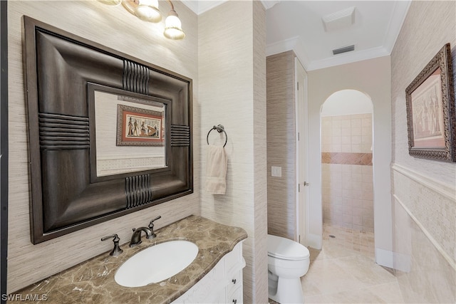 bathroom featuring toilet, vanity, crown molding, tile walls, and tile flooring