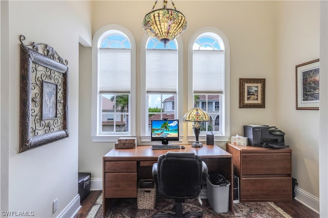 office space with an inviting chandelier and dark hardwood / wood-style flooring