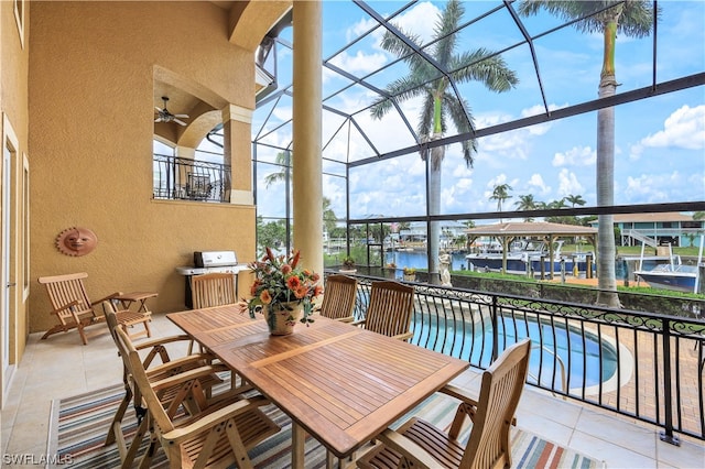 sunroom / solarium featuring a water view and ceiling fan