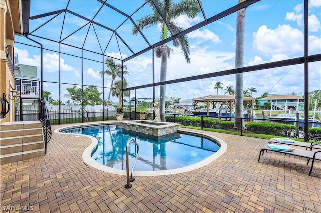 view of swimming pool with a patio area, an in ground hot tub, and a lanai