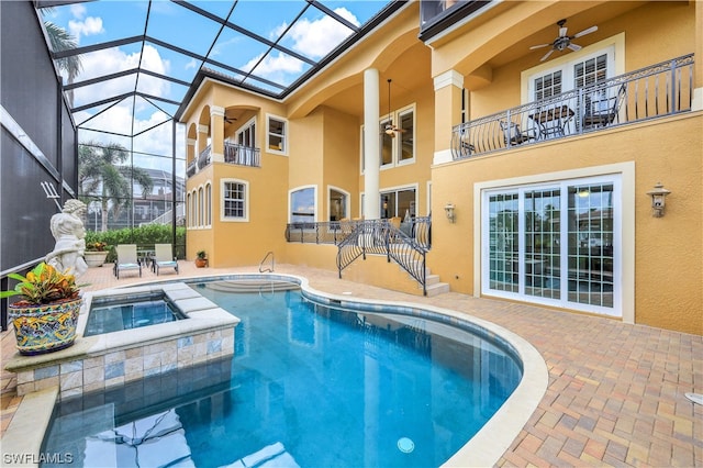 view of swimming pool with an in ground hot tub, ceiling fan, glass enclosure, and a patio