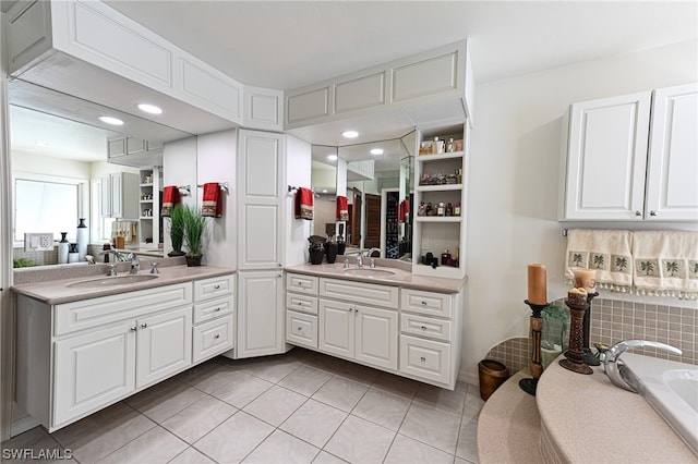 bathroom featuring oversized vanity, a washtub, double sink, and tile flooring