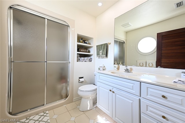 bathroom featuring oversized vanity, toilet, tile floors, and a shower with shower door