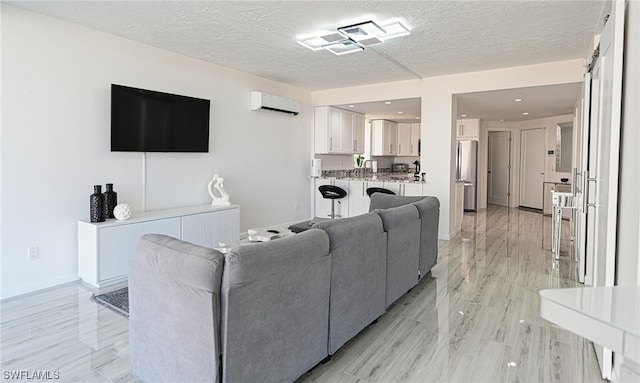 living room with a wall unit AC, a barn door, and a textured ceiling