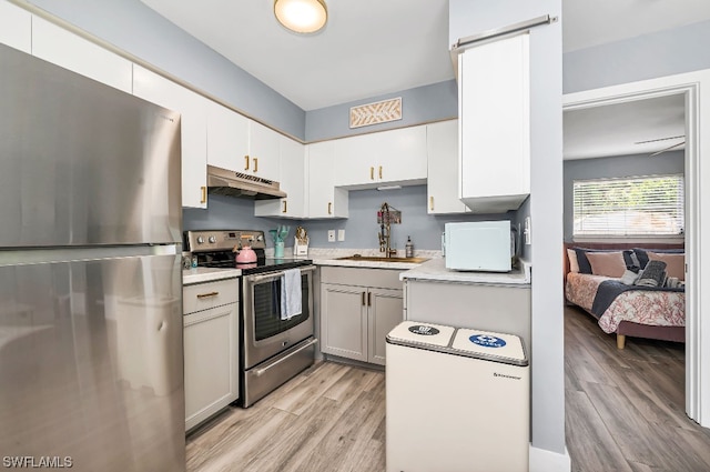 kitchen featuring white cabinetry, sink, appliances with stainless steel finishes, and light wood-type flooring