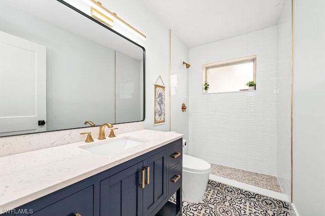 bathroom with vanity, tile flooring, a tile shower, and toilet