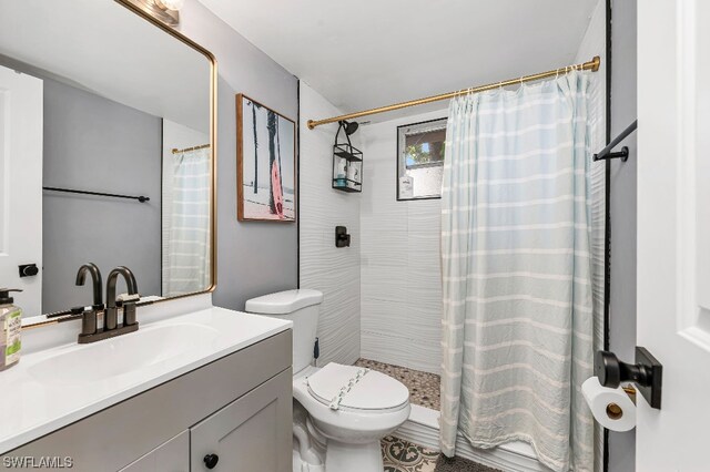 bathroom featuring walk in shower, toilet, and vanity