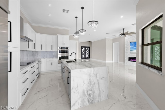 kitchen featuring black electric stovetop, stainless steel double oven, white cabinetry, and a spacious island