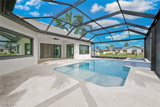 view of pool with an in ground hot tub, glass enclosure, ceiling fan, and a patio area