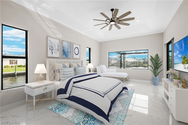 bedroom featuring multiple windows, a tray ceiling, and ceiling fan