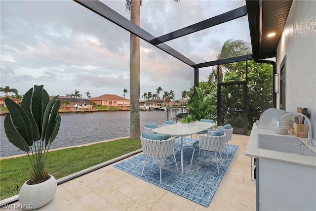 sunroom with a water view and sink