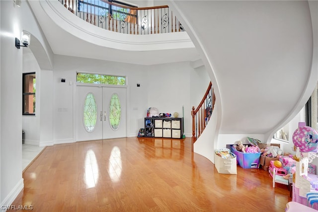 foyer featuring a high ceiling, french doors, and light hardwood / wood-style flooring