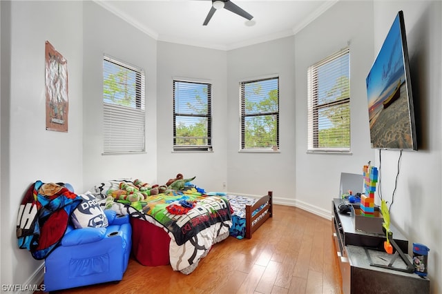 bedroom featuring ornamental molding, ceiling fan, and light wood-type flooring